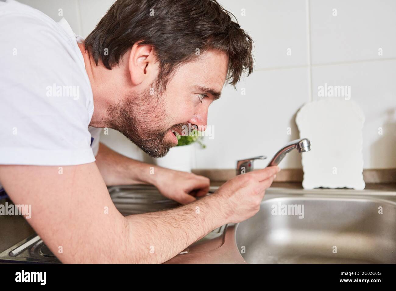 Do-it-yourselfer or professional plumber connecting the kitchen faucet Stock Photo