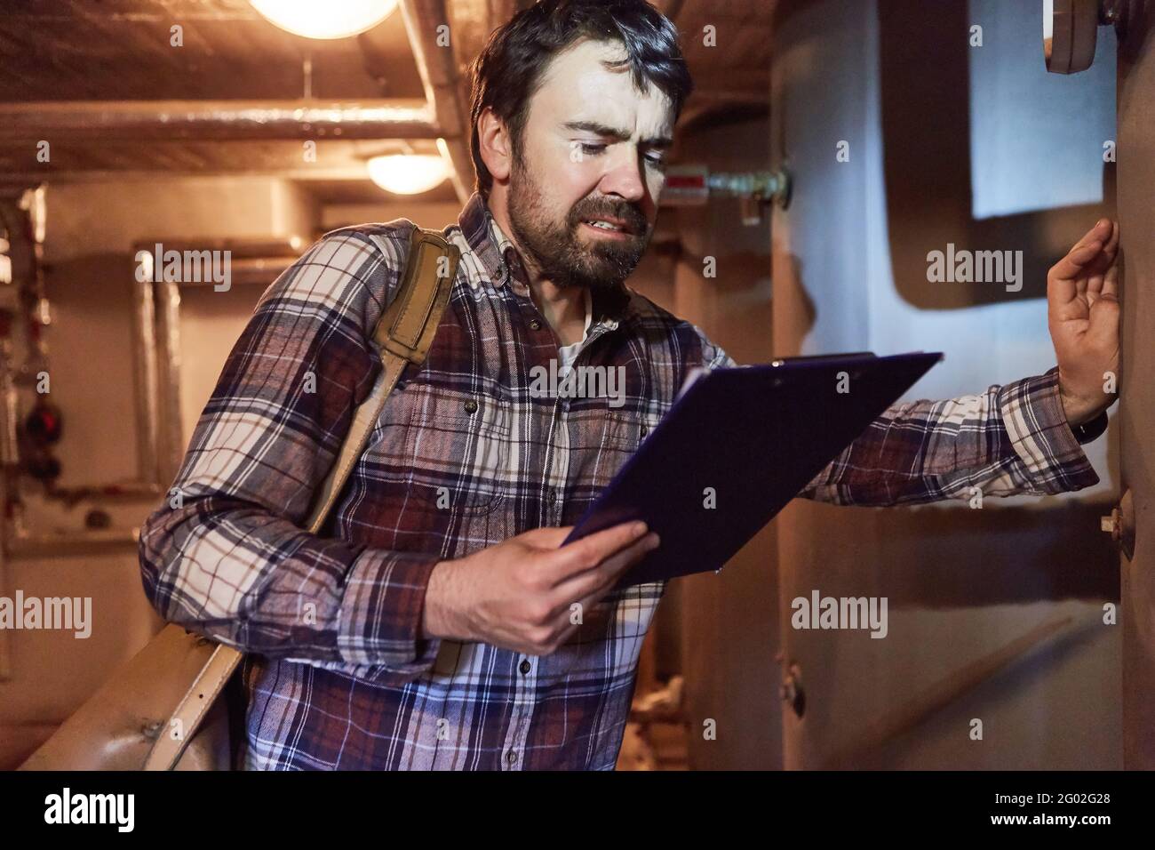 Heating installer checks condensing boiler of a gas heating system in