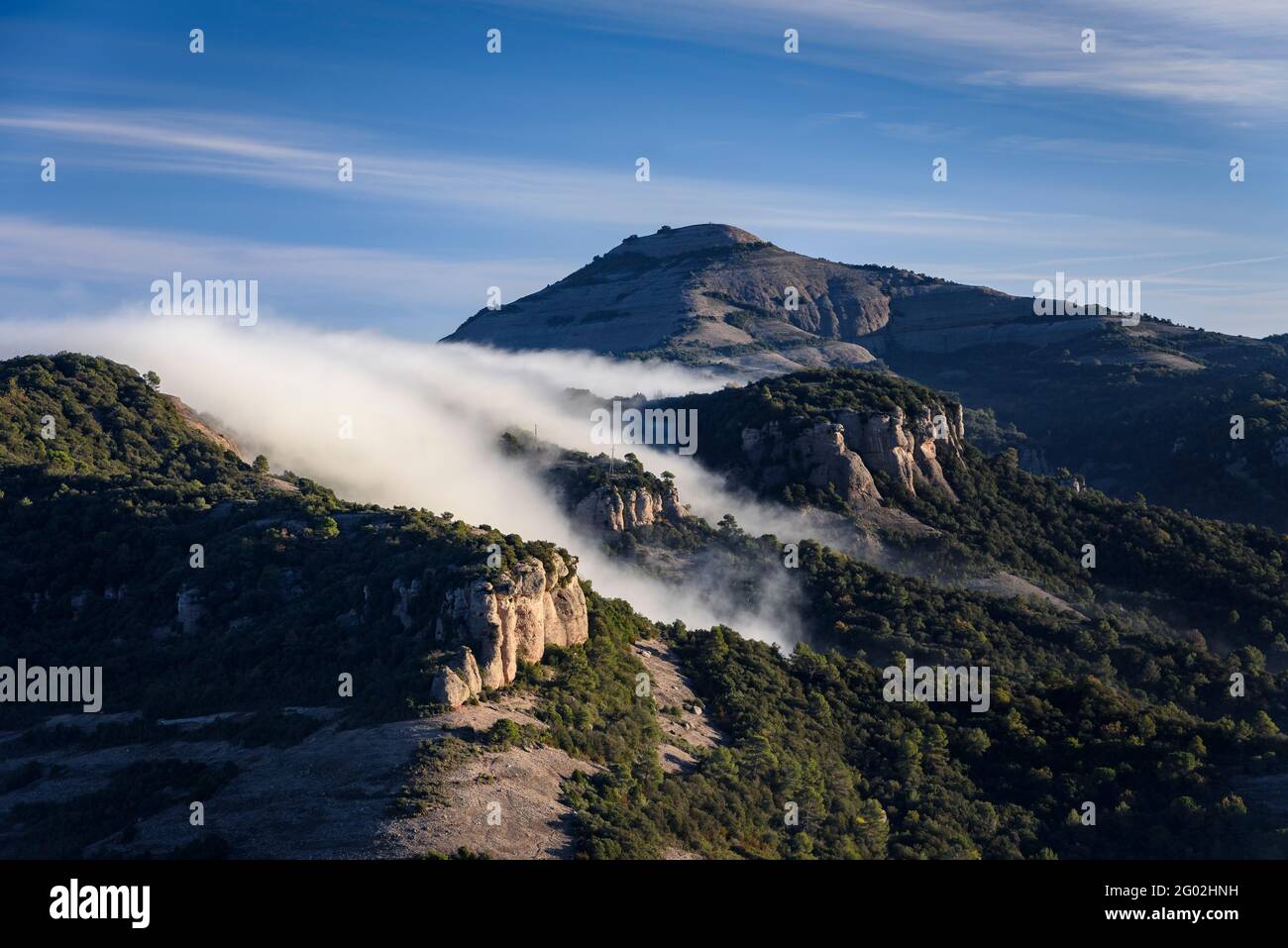 Fog crossing the Coll d'Estenalles mountain pass, below the Montcau peak (Sant Llorenç del Munt i l'Obac Natural Park, Barcelona, Catalonia, Spain) Stock Photo