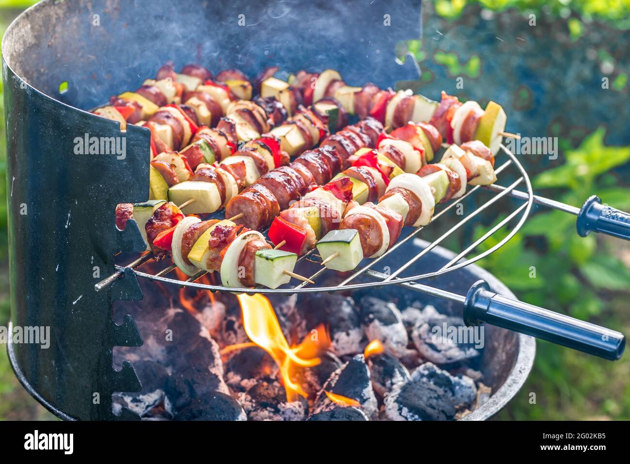 Vegetables and meat skewers on barbecue grill over fire and smoke, gilling  food outdoor in the summer backyard Stock Photo - Alamy