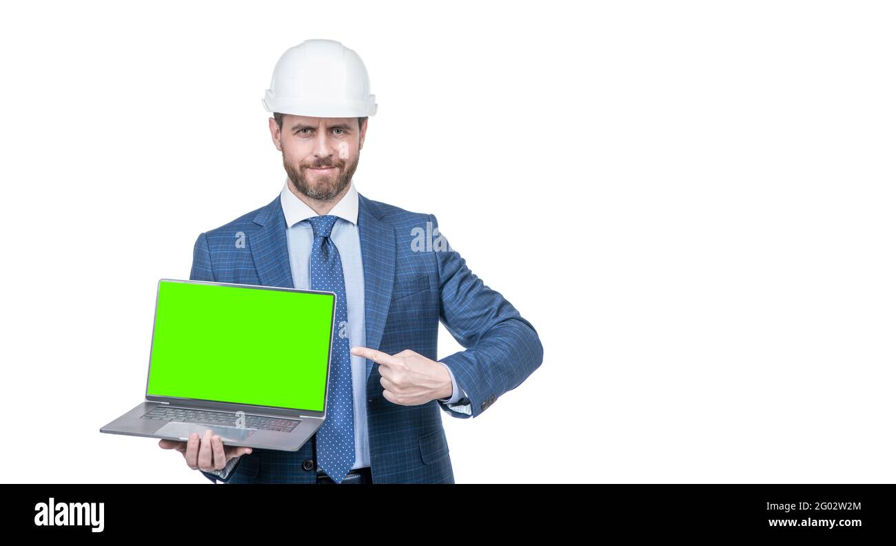 man in suit and safety helmet pointing finger on green screen of