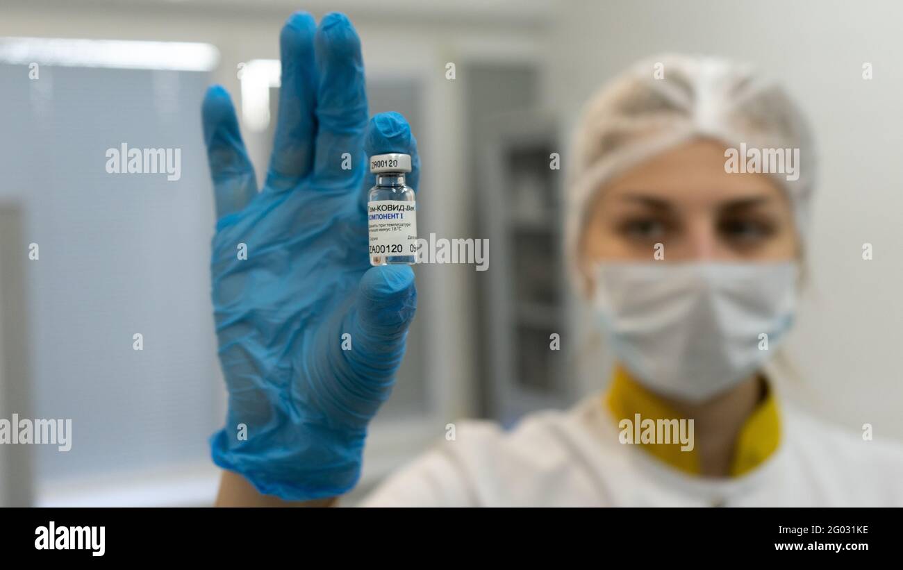 Moscow, Russia - 9 December 2020, Nurse in face mask and gloves showing ampule of Sputnik V vaccine on camera. Close up. Stock Photo