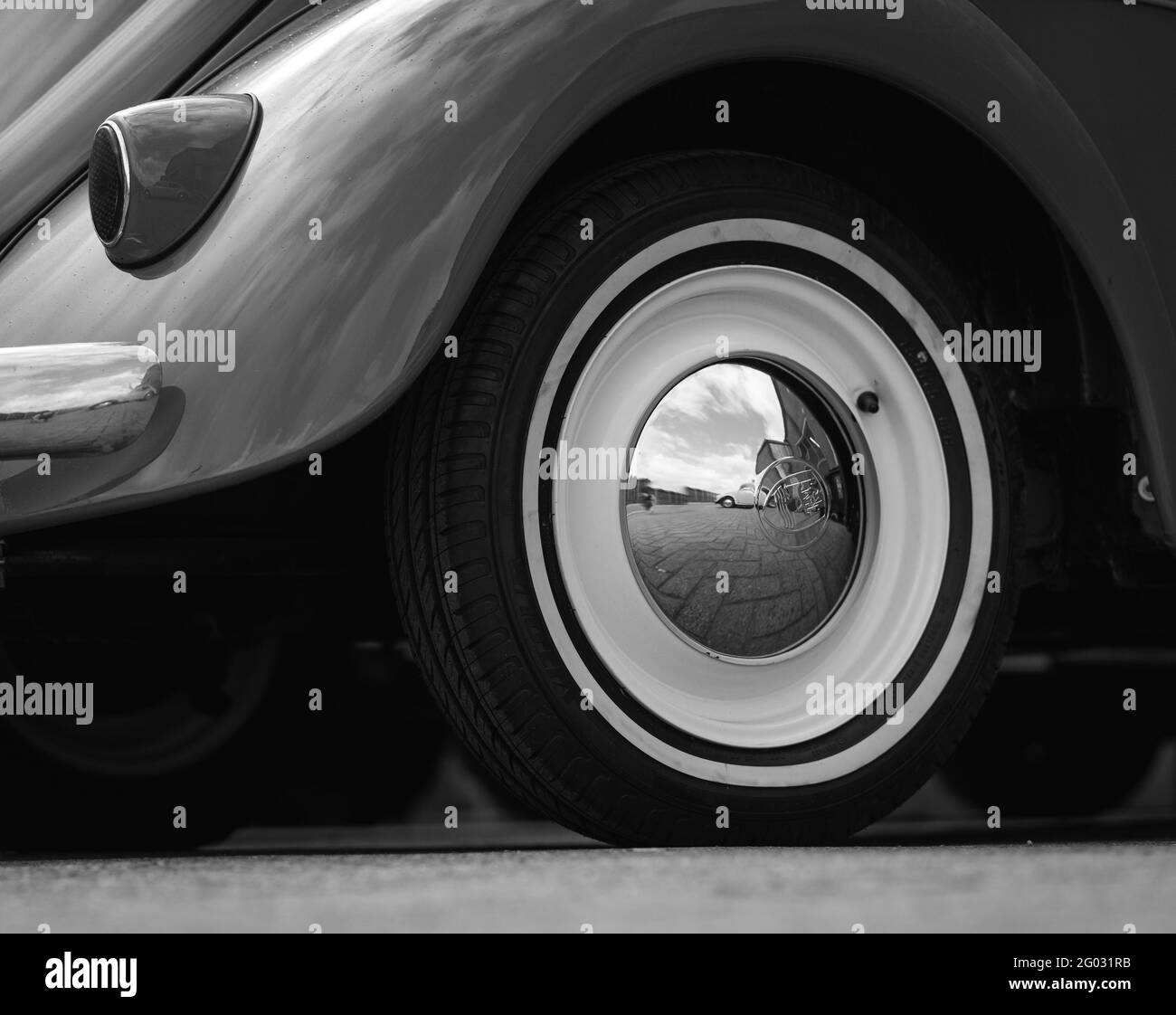 ZOETERMEER, NETHERLANDS - May 20, 2021: Retro car Volkswagen Beetle black and white shot of a rear wheel with a reflection of a VW Beetle in it. Stock Photo