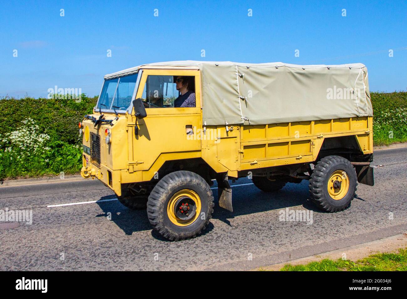 1977 70s seventies yellow British Army Land Rover 101 Truck canvas, heavy-duty four-wheel drive en-route to Capesthorne Hall classic May car show, Cheshire, UK Stock Photo