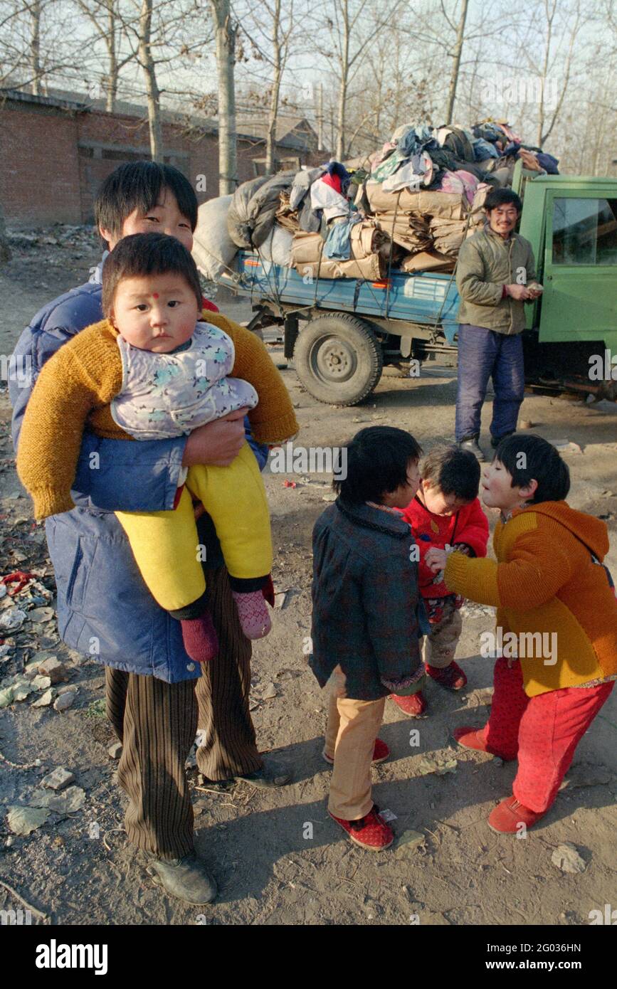 A couple from Henan province and four of their five children in Beijing, China in 1998. The youngest child in his mother's arms is the only boy. Stock Photo