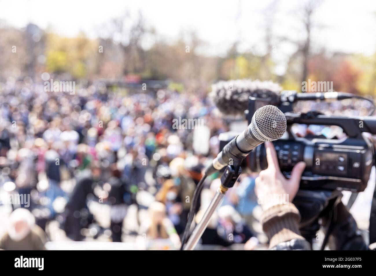 Protest or public demonstration, focus on microphone, blurred group of  people in the background Stock Photo - Alamy