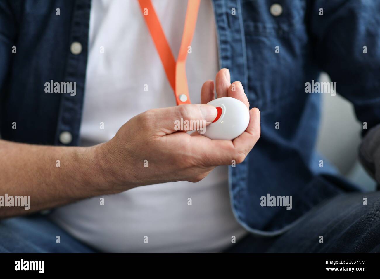 Unrecognizable old man pushing red button for emergency Stock Photo
