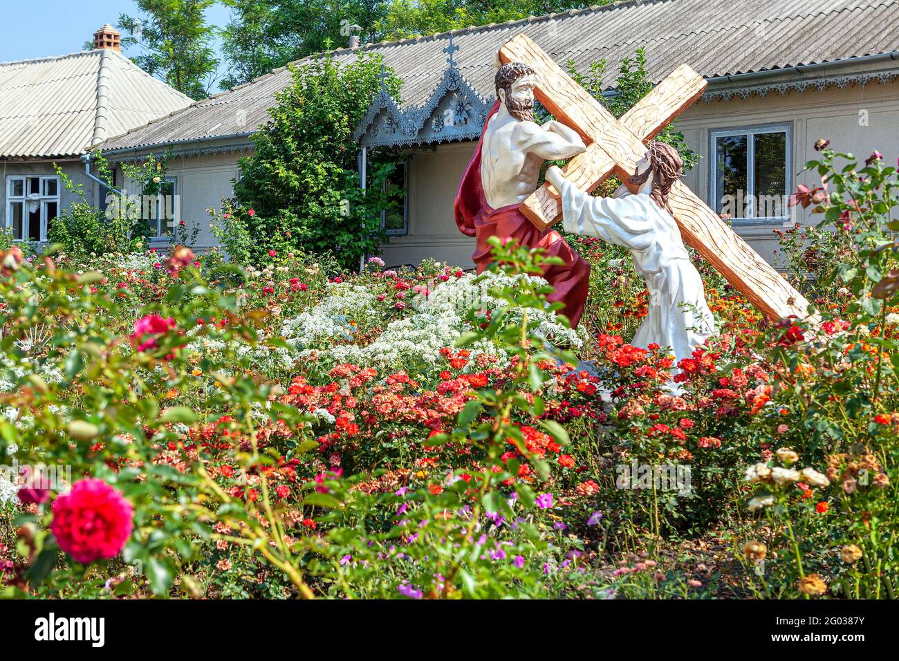 Religious sculptures in the garden . Statue of Jesus with Cross and
