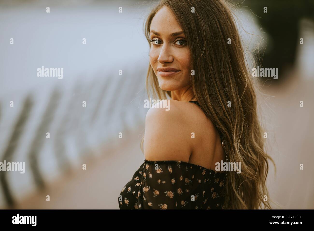 Pretty young long hair brunette woman walking on the riverside Stock ...