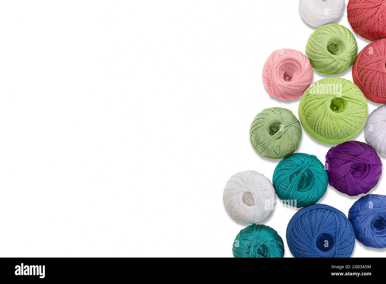 Multicolored balls and bobbins of woolen yarn, wooden thread sleeves on white isolated background. Needlework, handmade.  view from above. Isolated. C Stock Photo