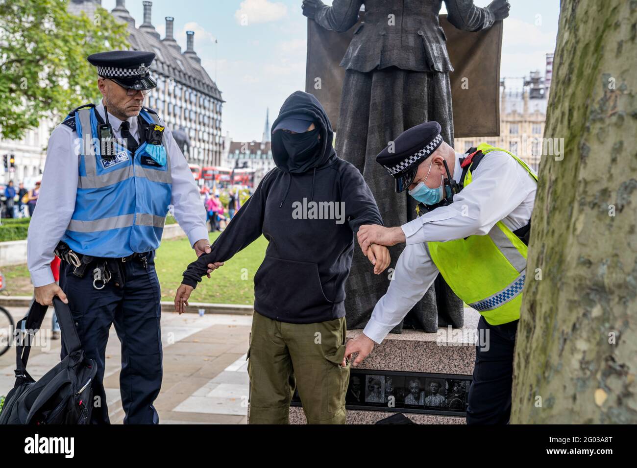 LONDON, UK – Two Metropolitan Police officers perform a body search and arrest of an Extinction Rebellion demonstrator during a protest. Stock Photo