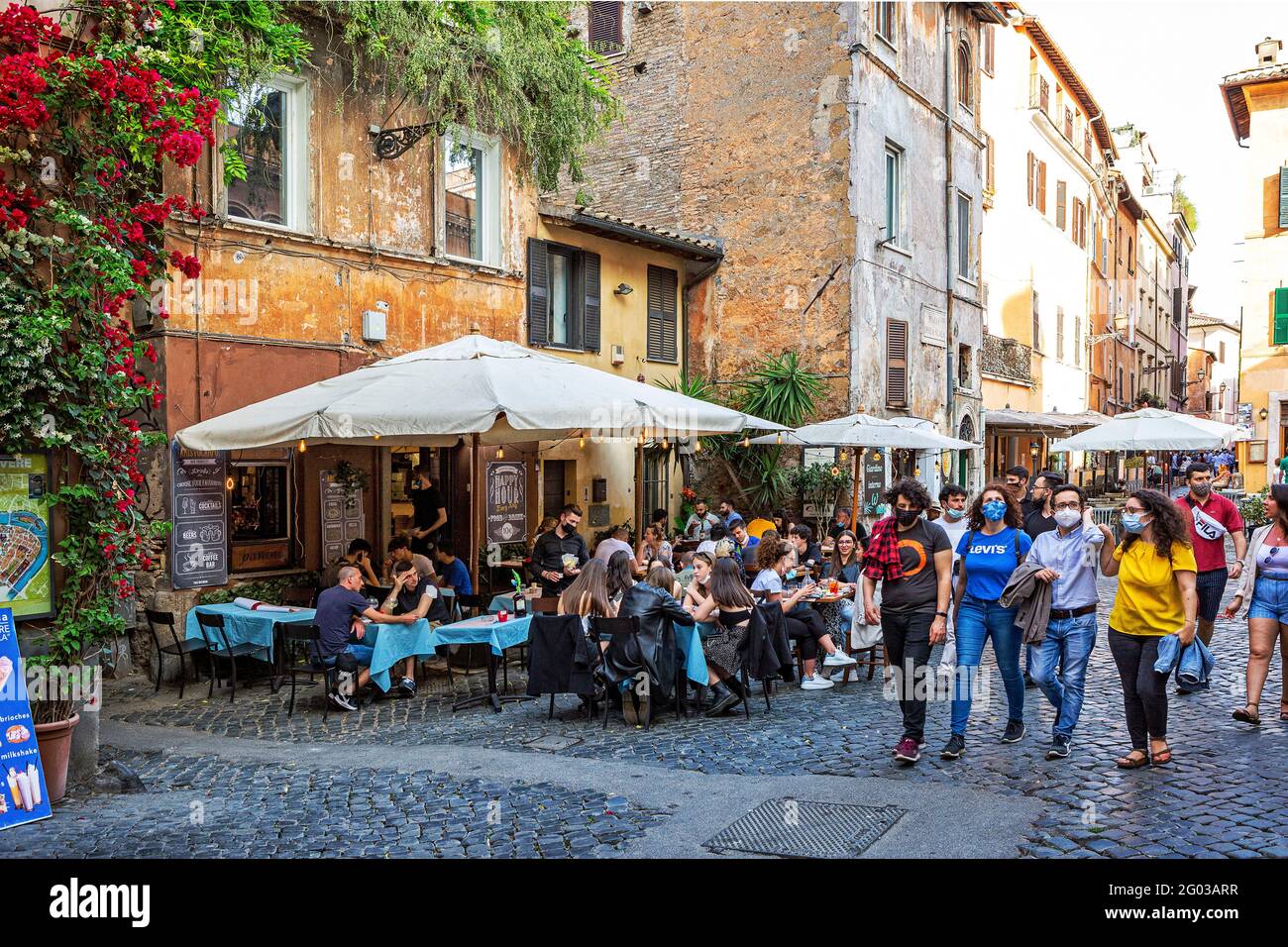 People sit outside a café in the artistic tourist area of Trastevere in Rome Stock Photo