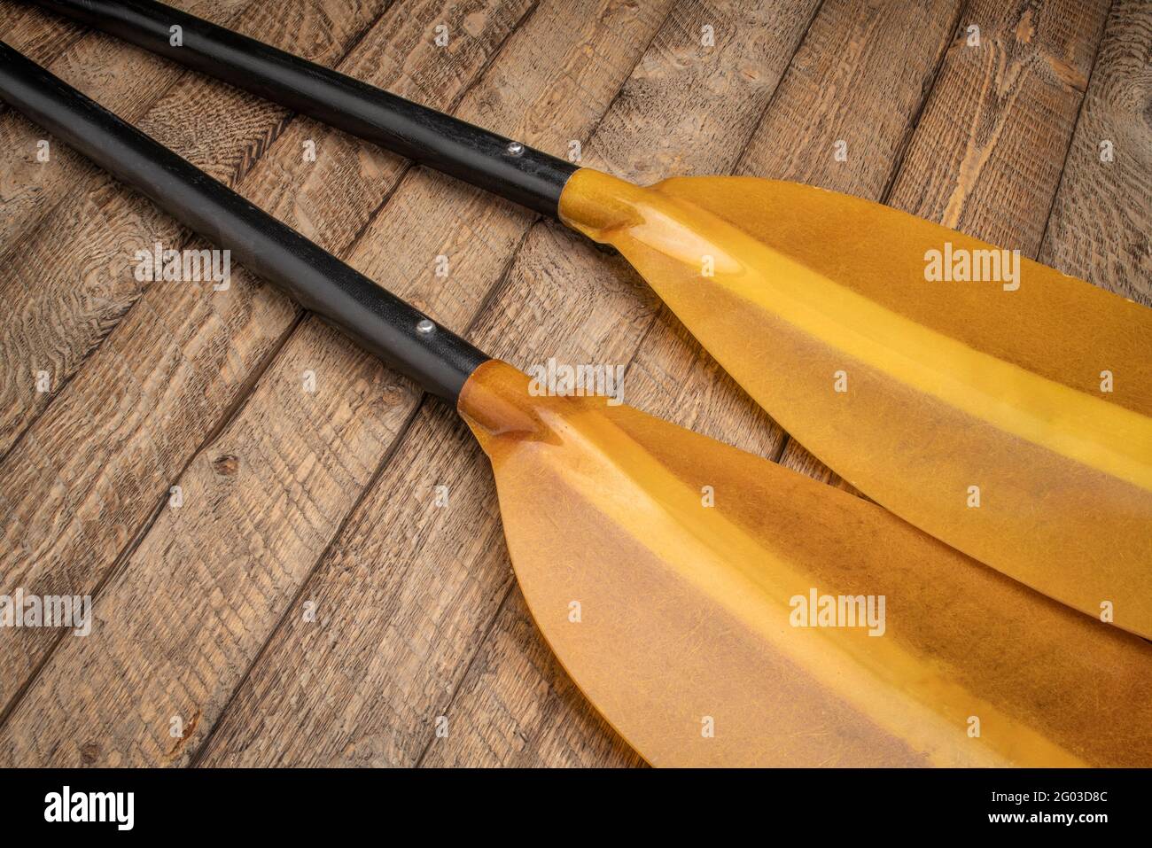 takeapart fiberglass whitewater kayak paddle against weathered wood