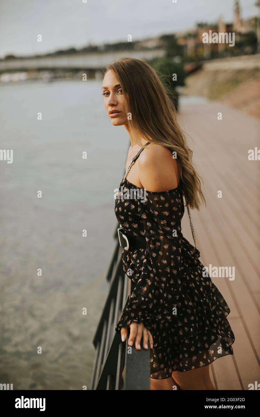 Pretty young long hair brunette woman standing on the riverside Stock ...