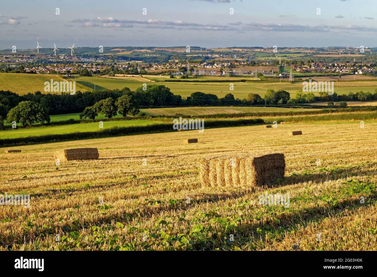UK, South Yorkshire, Rotherham, Hay Bales in Filed overlooking the town