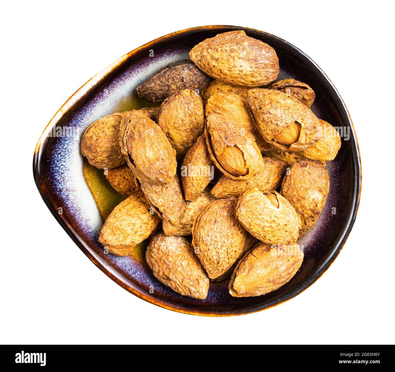 top view of cracked almond drupes in ceramic bowl isolated on white