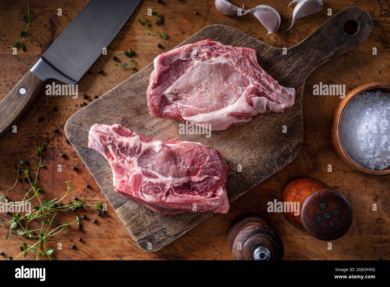 Raw organic pork chops on a rustic table top. Stock Photo