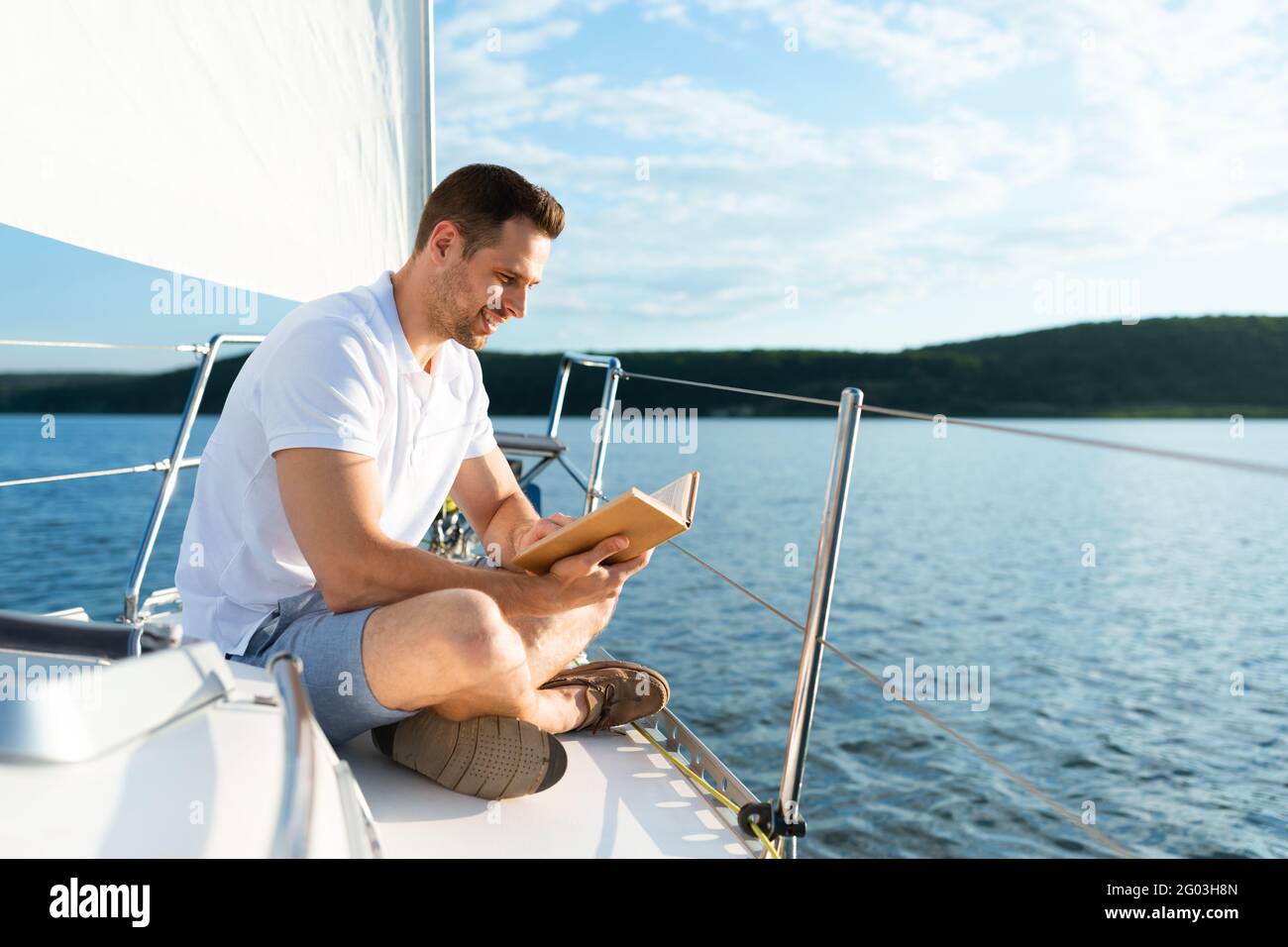 Man Reading Book Sitting On Yacht Deck Sailing In Sea Stock Photo Alamy