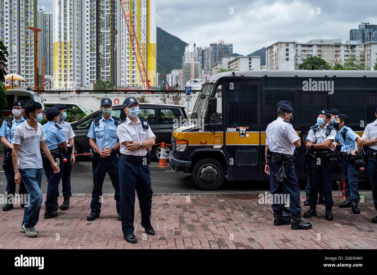 Hong Kong, China. 31st May, 2021. Police officers stand on guard as a Correction Services Department van arrives at the West Kowloon Law Courts Building in Hong Kong.47 pro-democracy activists have been charged under the national security law for subverting state power for participating in an unofficial primary in 2020 to choose pro-democracy candidates for the since-postponed legislative election. (Photo by Miguel Candela/SOPA Images/Sipa USA) Credit: Sipa USA/Alamy Live News Stock Photo