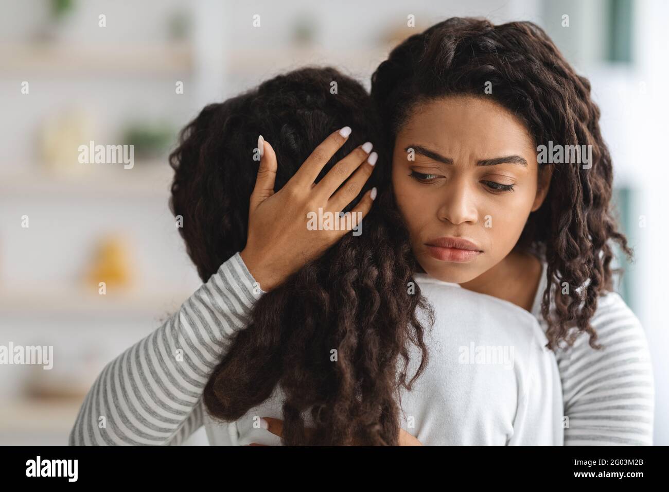 Worried young black mother comforting her crying daughter Stock Photo