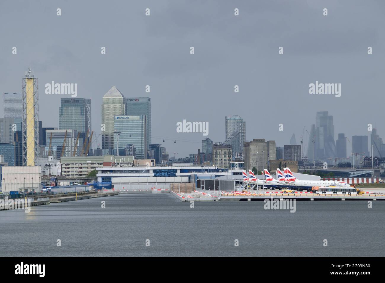 Storm clouds overhead Canary Wharf and London City Airport Stock Photo