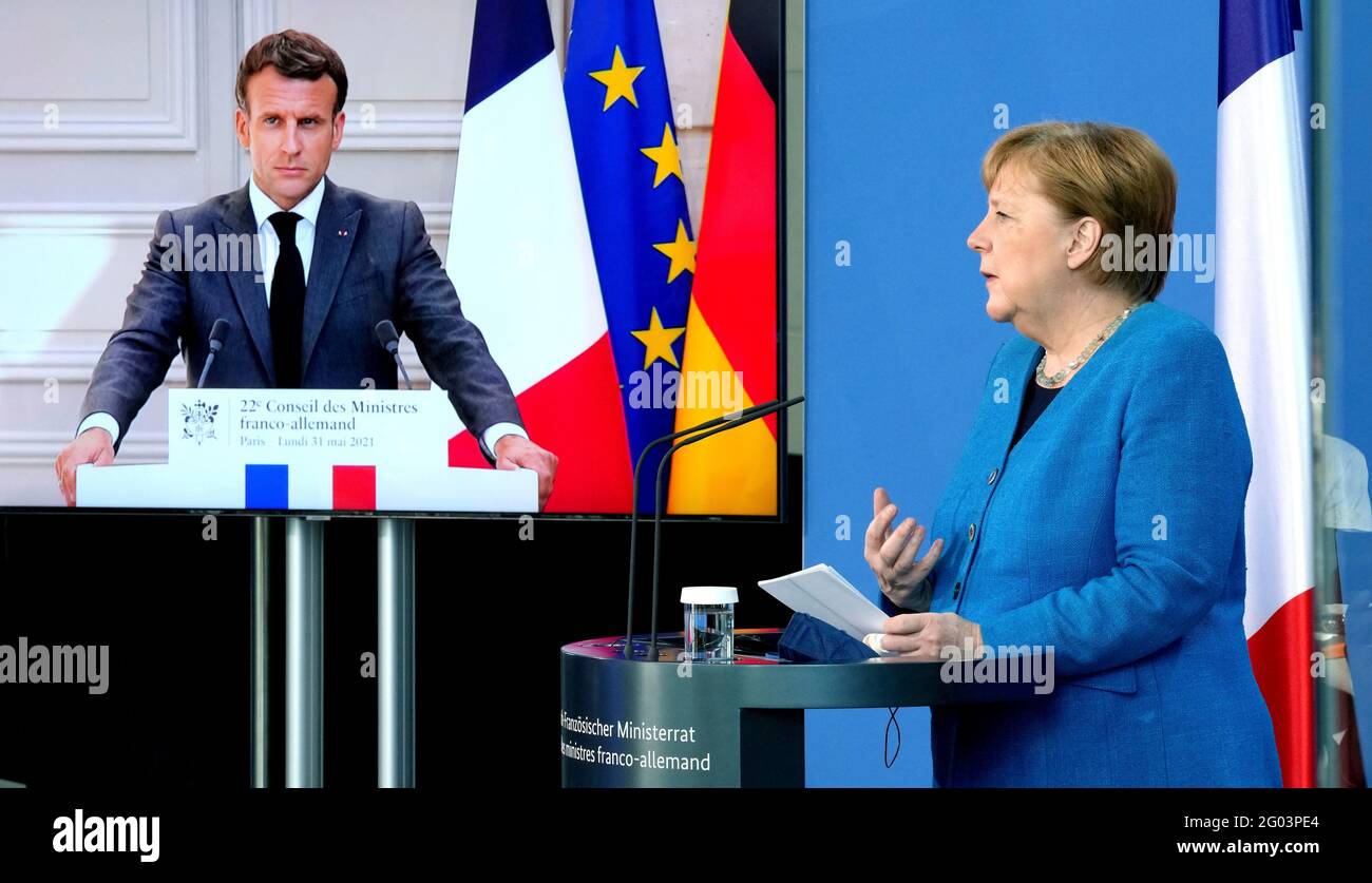 Berlin, Germany. 31st May, 2021. France's President Emmanuel Macron is seen on a screen during a joint press conference with German Chancellor Angela Merkel. Credit: Michael Sohn/POOL AP/dpa/Alamy Live News Stock Photo
