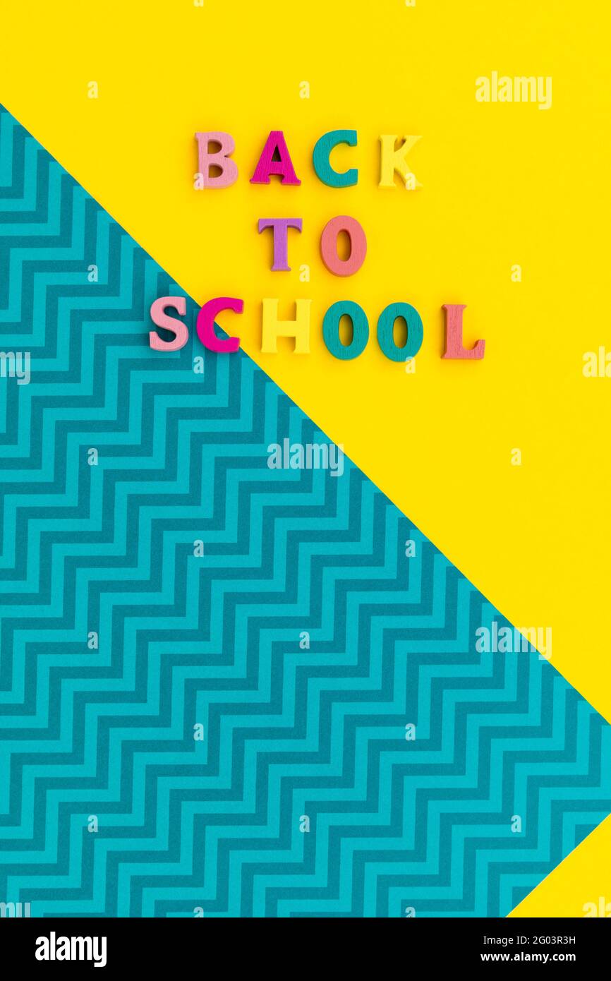 Flat lay top view text back to school on yellow and blue background ...
