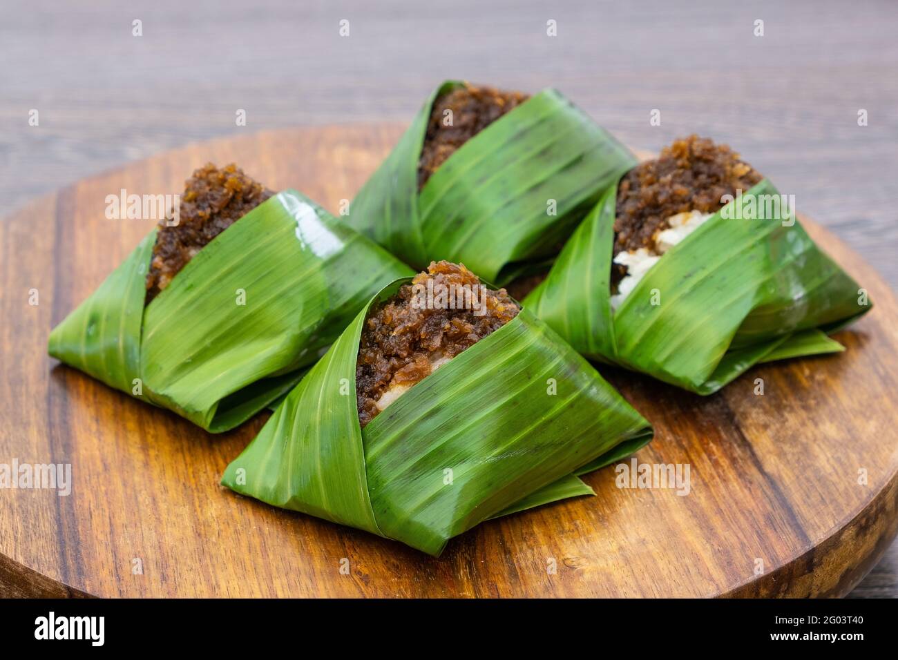 Kuih Pulut inti, traditional Malaysian dessert. Savory glutinous rice with  sweetened grated coconut wrapped in banana leaf Stock Photo - Alamy