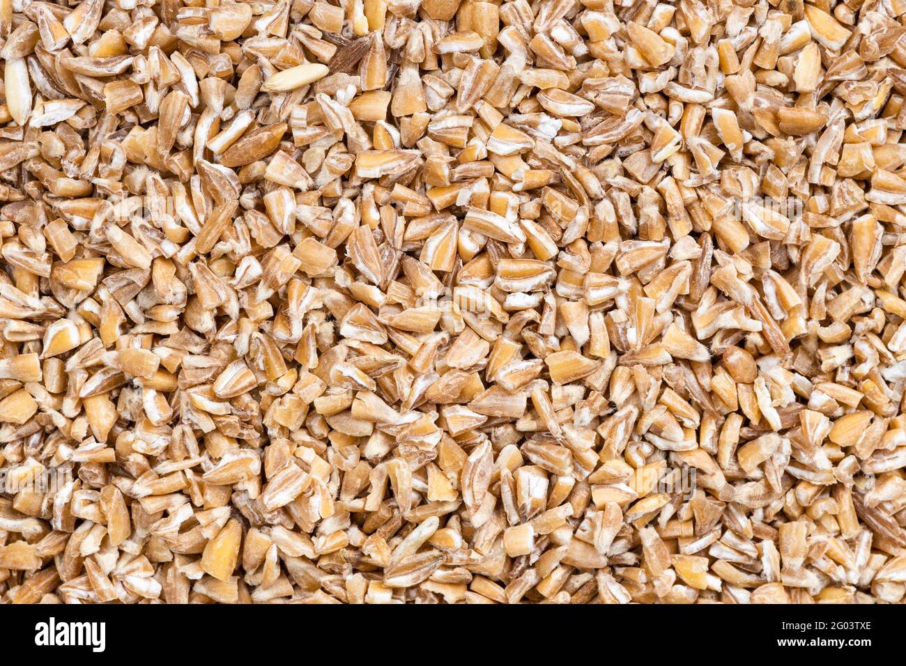 food background - uncooked crushed Emmer farro hulled wheat groats Stock Photo