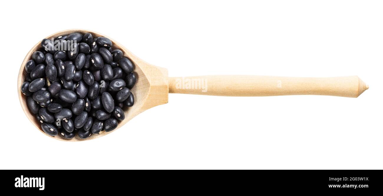 top view of wood spoon with uncooked black mexico beans isolated on white background Stock Photo