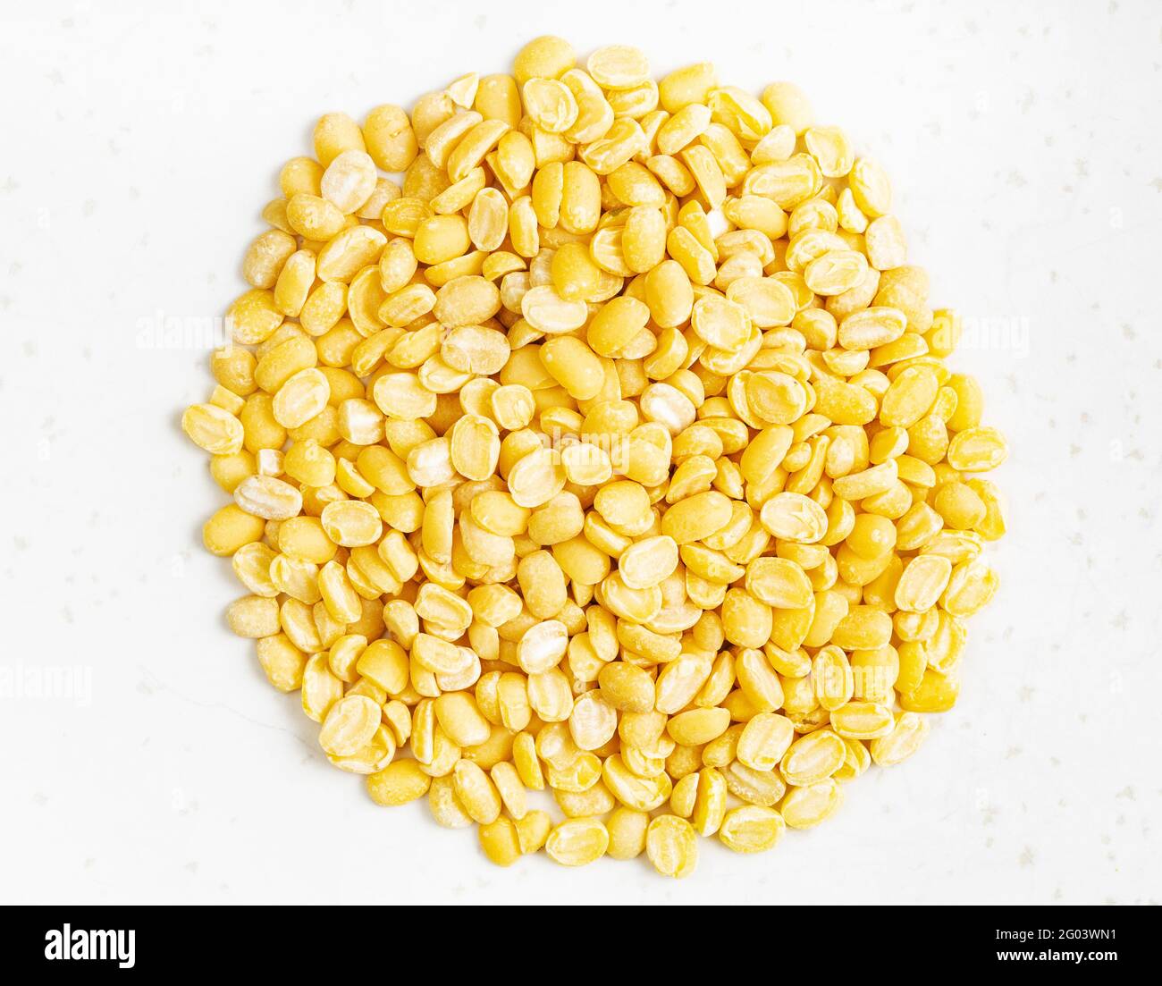pile of raw moong dal (split green mung) beans close up on gray ceramic plate Stock Photo
