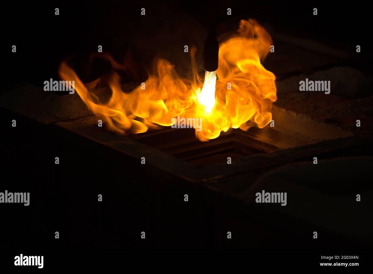 Flames shooting out in the process of casting glass art. Stock Photo