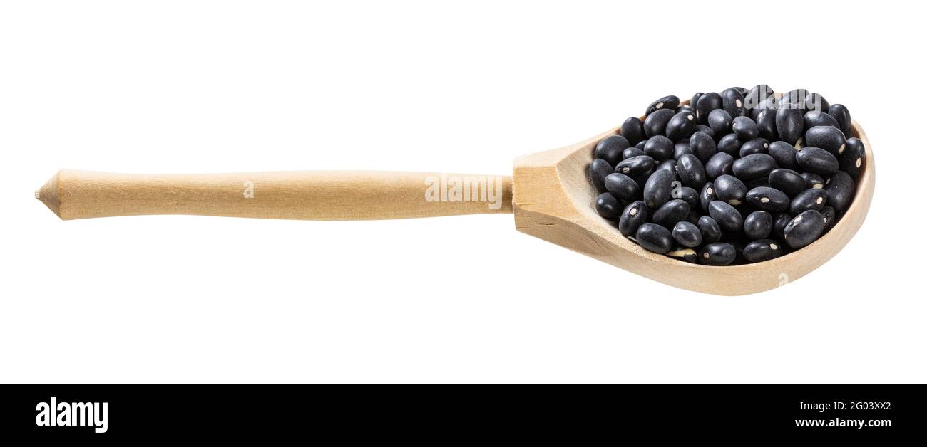 wooden spoon with uncooked black mexico beans isolated on white background Stock Photo