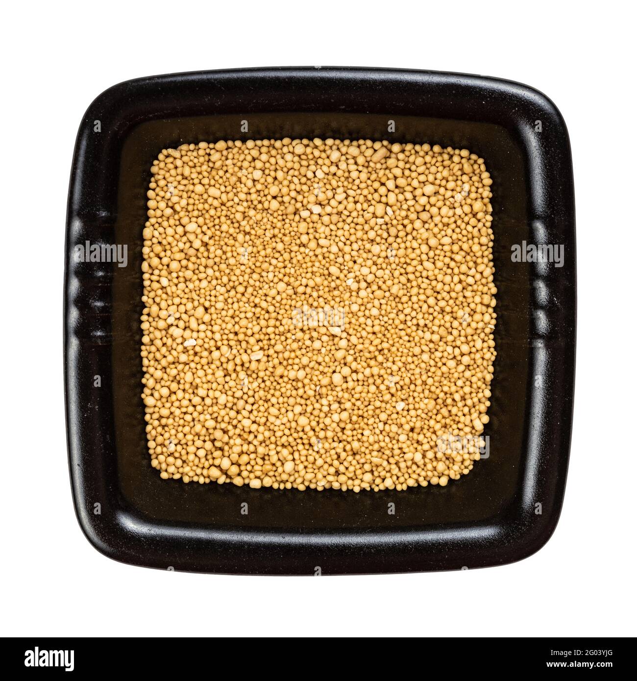 top view of granulated dried yeast in black bowl isolated on white background Stock Photo