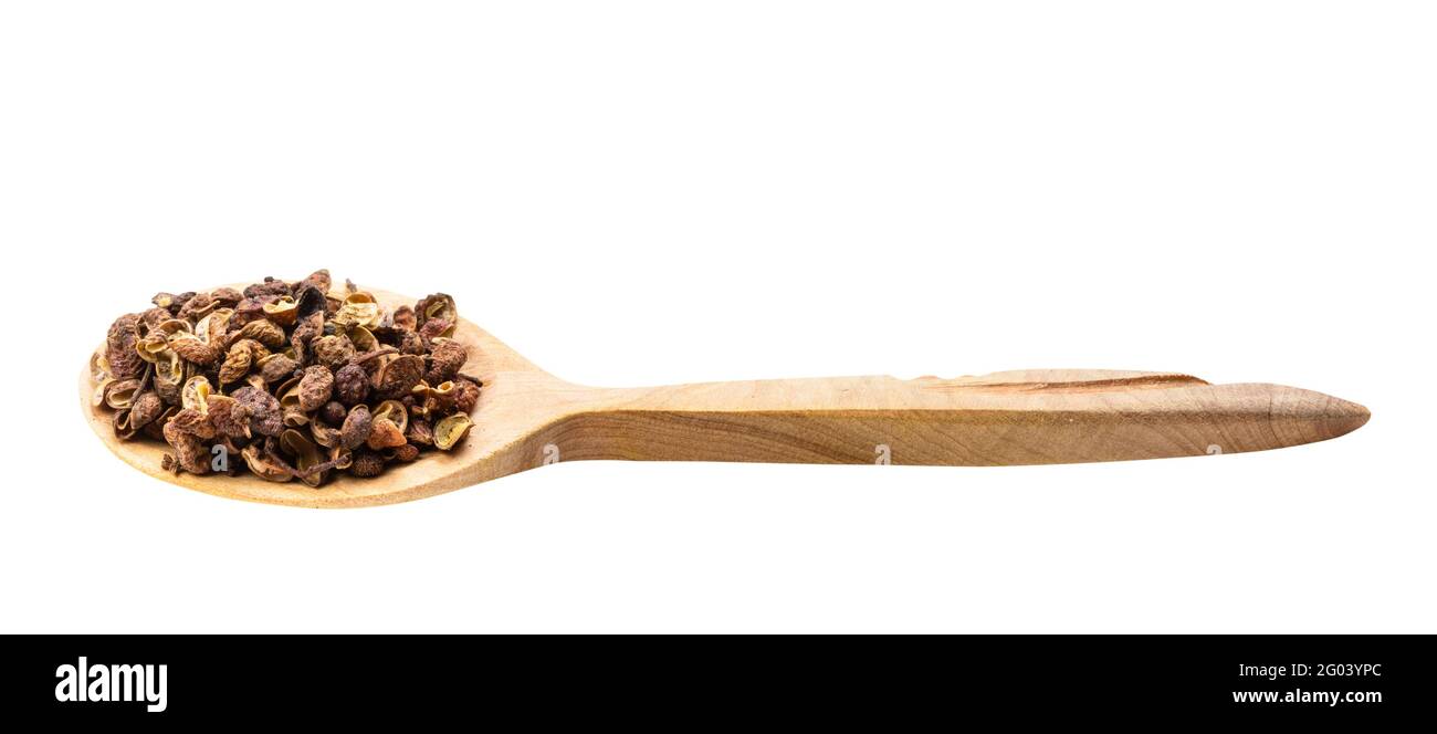 dried pink sichuan pepper in wooden spoon isolated on white backgrouns Stock Photo