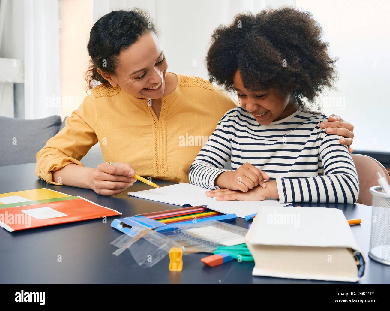 Professional female psychologist works with African American little girl. Positive child during a psychotherapy session Stock Photo