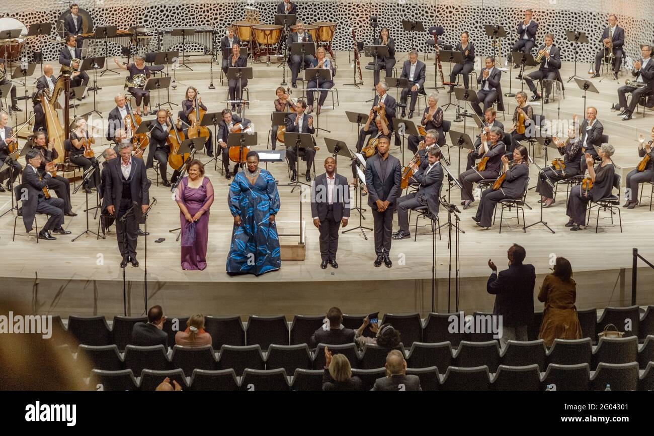 Hamburg, Germany. 31st May, 2021. Members, soloists and Roderick Cox conductor of the Deutsche Kammerphilharmonie Bremen (standing, r), accept the audience's applause during the intermission. With their concert 'Song of America. A celebration of black music', the Elbphilharmonie opened its season after the forced Corona break. Credit: Markus Scholz/dpa/Alamy Live News Stock Photo
