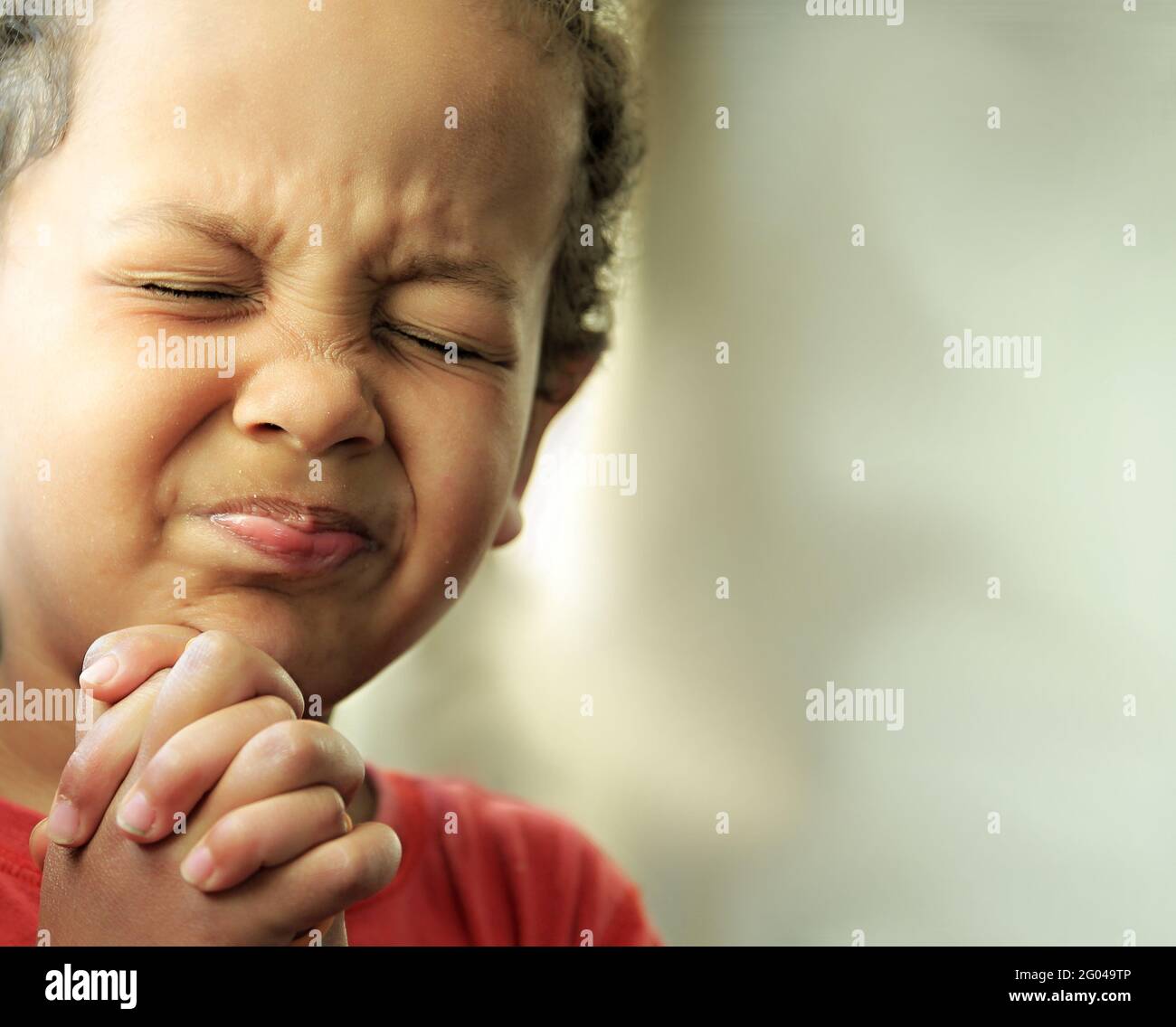 boy praying to god with closed eyes and hands held together stock photo  Stock Photo - Alamy