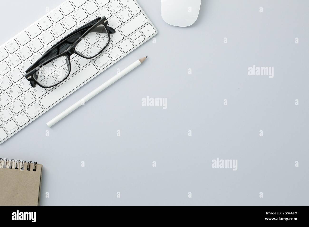 Glasses mouse pencil keyboard and notepad on white background Stock Photo