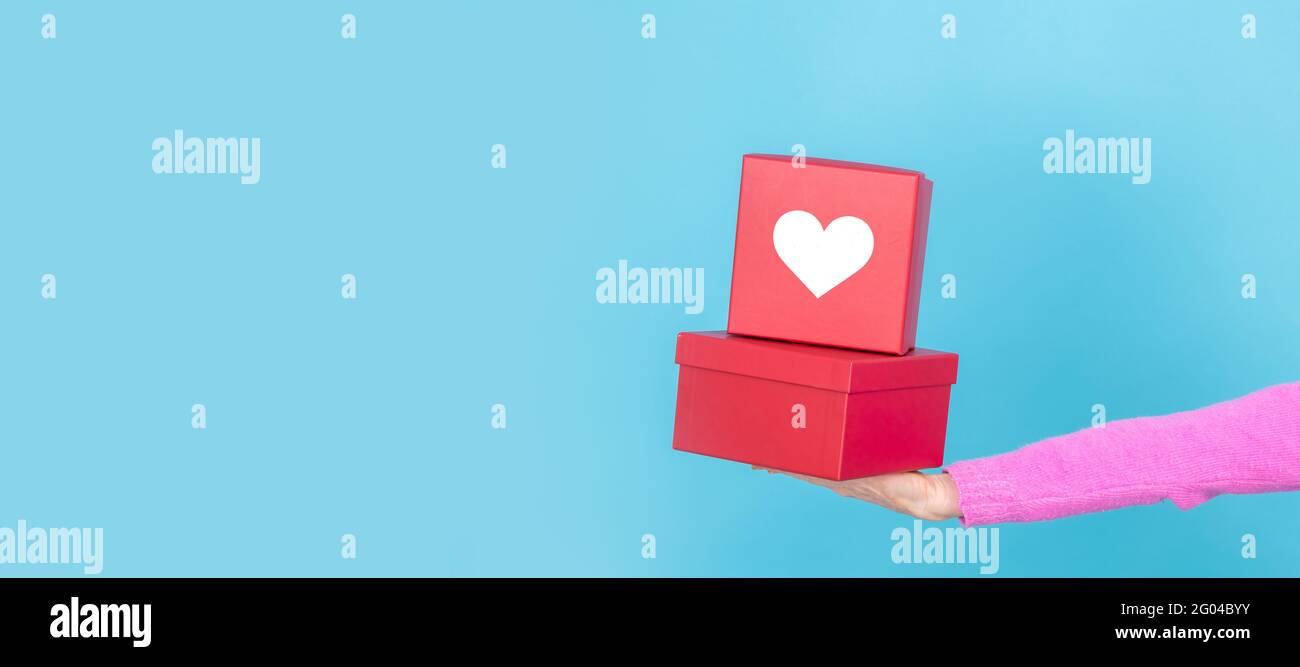 hands with gift boxes with heart isolated on background Stock Photo