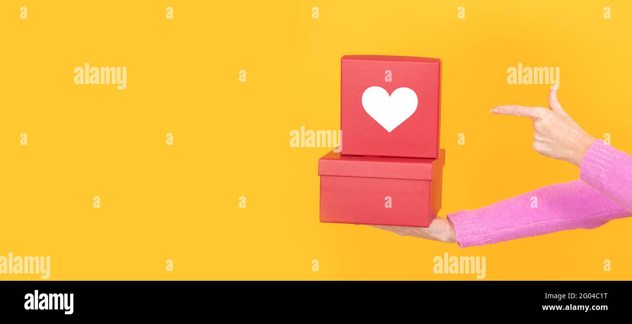 isolated hands with stacked gift boxes with heart Stock Photo