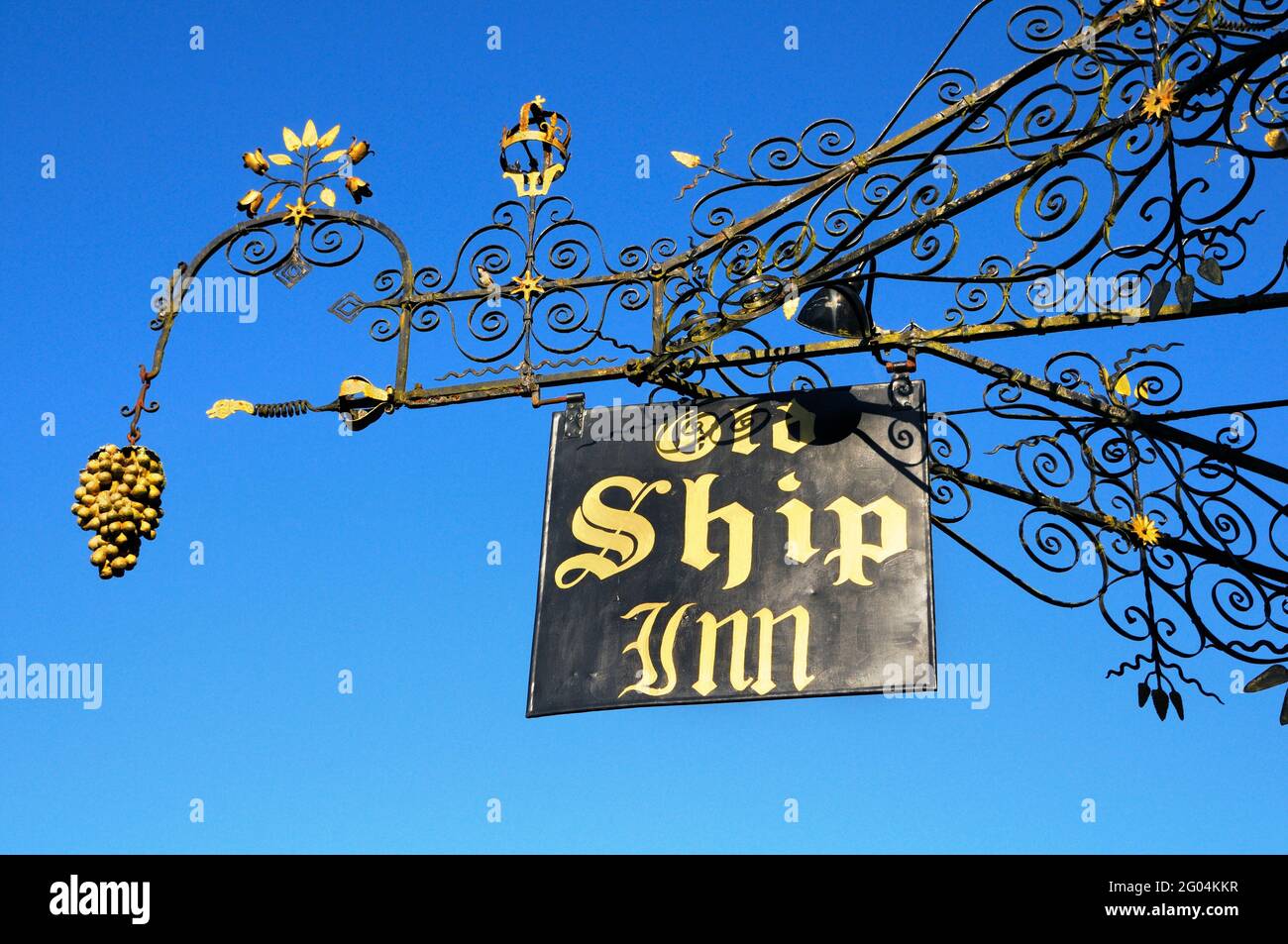 Ornate wrought iron pub sign against blue sky, Old Ship Inn, Mere, Wiltshire, England, UK Stock Photo