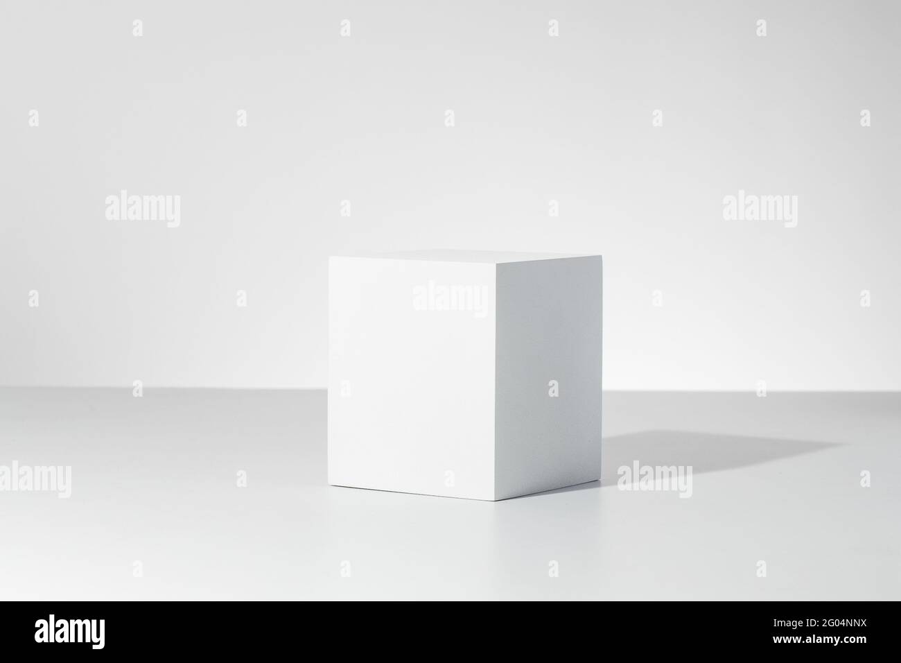 3D render of a simple square block casting a shain a bright white room ...