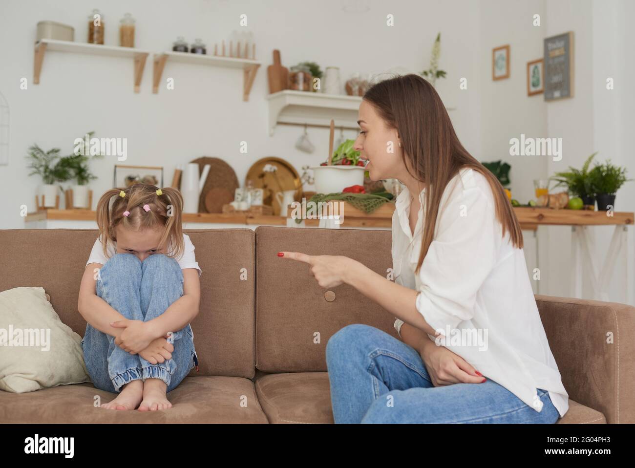 Single mother and little child are sitting at home on the couch, parent