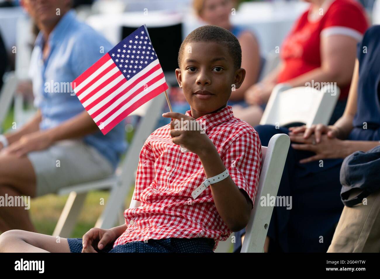 A young guest attending the 2020 Salute to America event waves an American flag as President Donald J. Trump delivers remarks Saturday, July 4, 2020, on the South Lawn of the White House Stock Photo