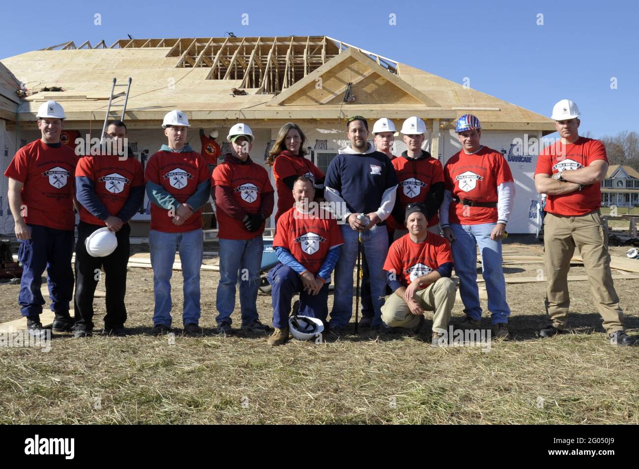 Reportage:   QUEEN ANNE, Md. - Members from Coast Guard Sector Baltimore pose with Marine Sgt. Christopher Santiago (in blue shirt) during a Homes for Our Troops Build Brigade, Nov. 17, 2012. An estimated 150 volunteers from the community, including members of the Coast Guard, spent two days constructing the specially adapted home for Santiago, who lost both of his legs and severely injured his left arm when he stepped on an improvised explosive device while deployed to Iraq in 2006. Stock Photo