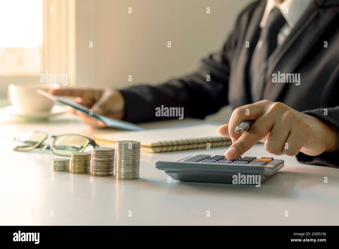 The businessman is holding a pen and pressing to a calculator, ideas for planning for investment and money growth. Stock Photo