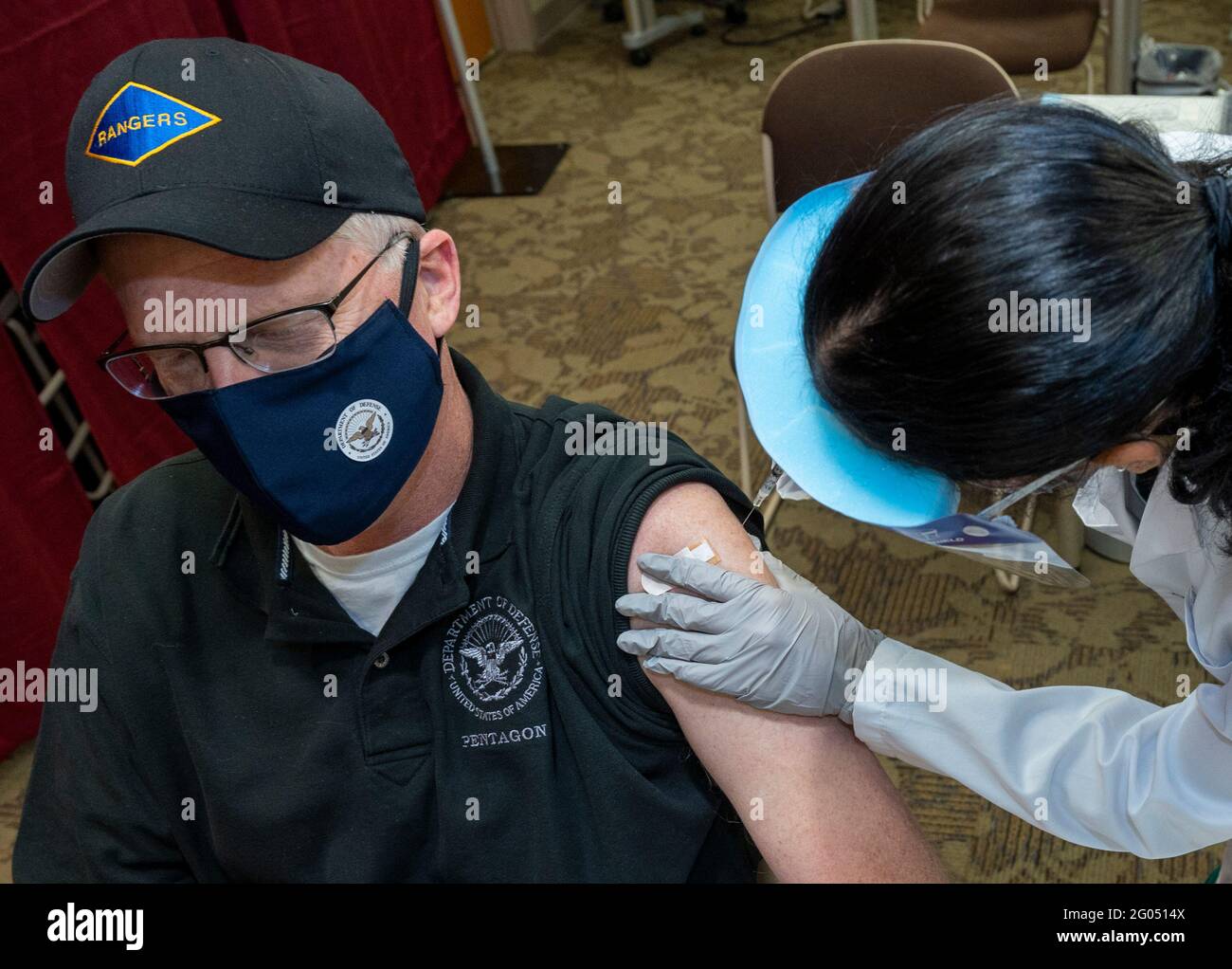 Reportage:  Acting Defense Secretary Chris Miller receives a COVID-19 vaccine from Navy Hospitalman Samantha Alvarez, Walter Reed National Military Medical Center, Bethesda, Md., Dec. 14, 2020. Stock Photo