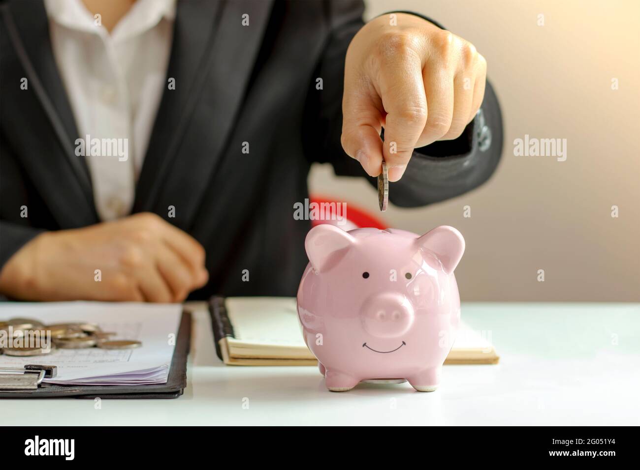 Business women who hold coins in a piggy bank closely, including ...