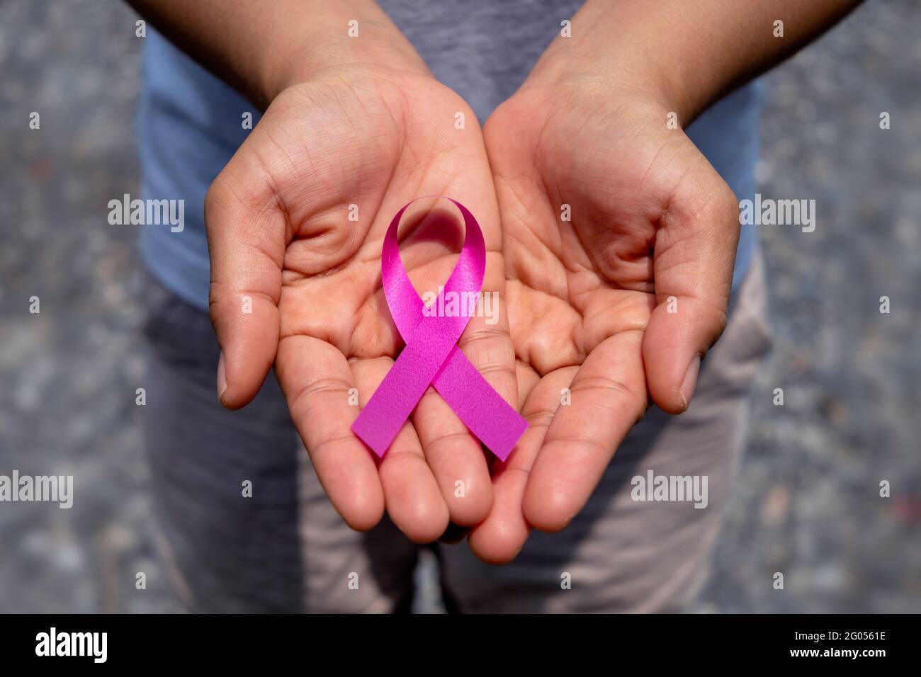 Pink ribbon on female hand, healthcare concept and breast cancer symbol. Stock Photo